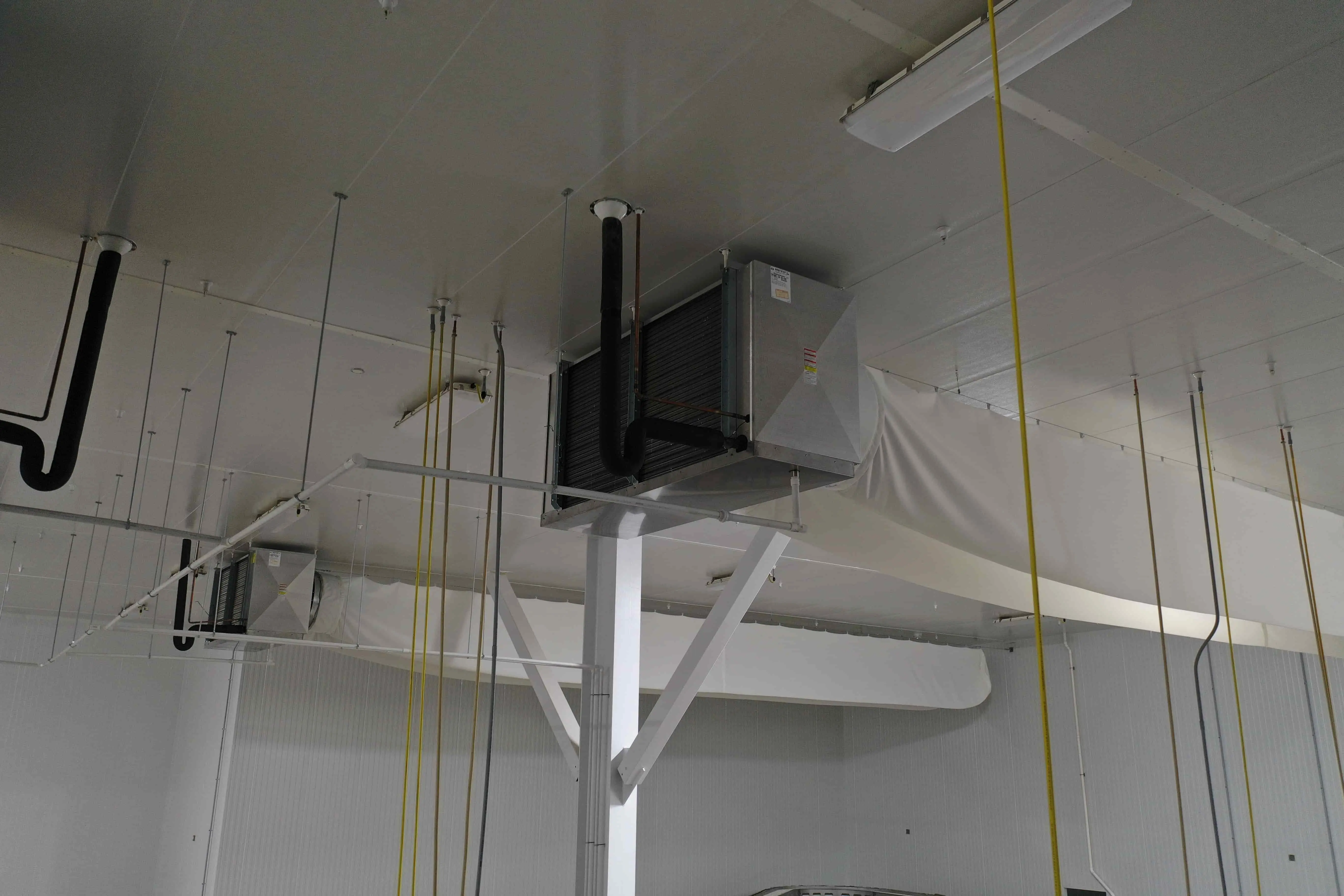 SB6023b: EVAP 2B Evaporative Cooler – Trenton THP106ME-T4A-SN Dual-Fan High-Profile Evaporator with Fabric Duct (~15 000 CFM, 460 V 3-Phase) – EVAP 2B Located Mid-South Wall of 37 °F Cold Pack Room